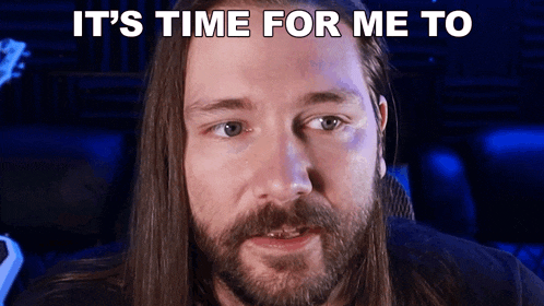 a man with long hair and a beard is looking at the camera with the words it 's time for me to above him .