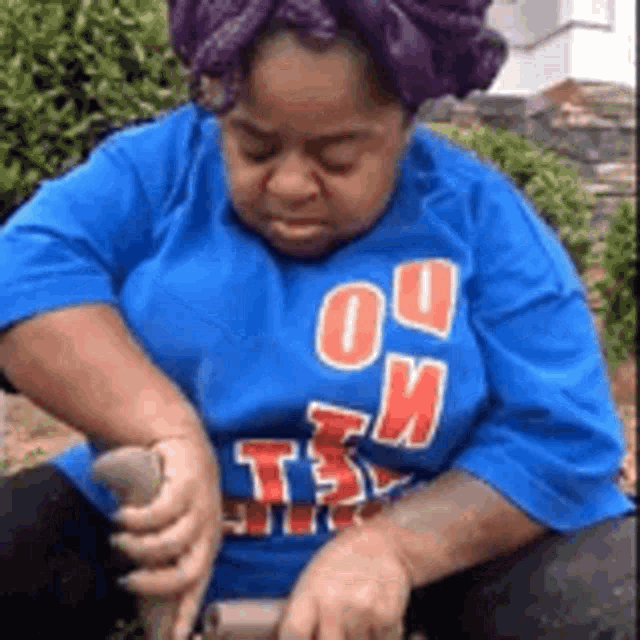 a woman wearing a blue shirt with the word tsv on it is kneeling down .