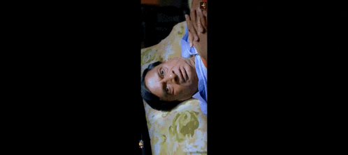 a man is laying on his stomach on a bed with his eyes closed .