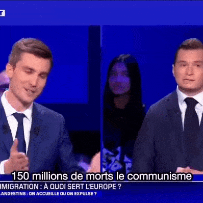 a man in a suit and tie is talking to another man in a suit and tie on a television show .