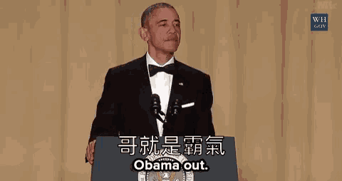 obama is giving a speech at a podium in a suit and tie while holding a wand .