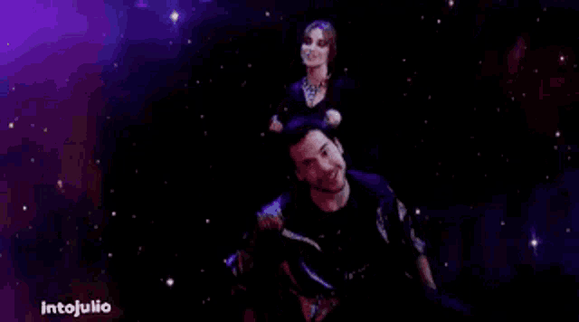 a man and a woman are dancing in a dark room with purple lights .