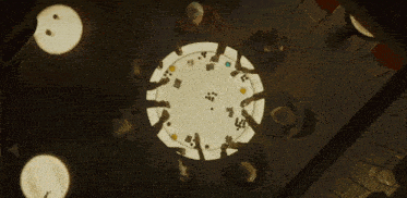a group of people are sitting around a table with cards and dice on it