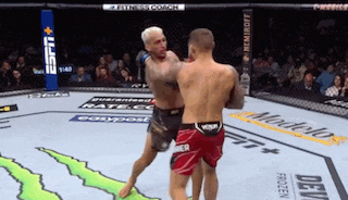 two men are fighting in a boxing ring with a monster energy logo on the floor .