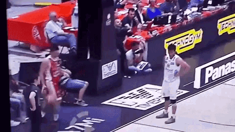 a basketball player is standing on the court in front of a panasonic sign
