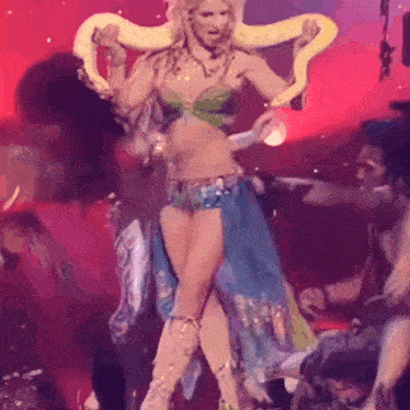 a woman is dancing with a snake around her neck .