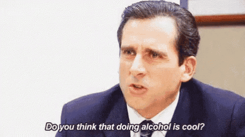 a man in a suit and tie is sitting at a desk and talking to someone .