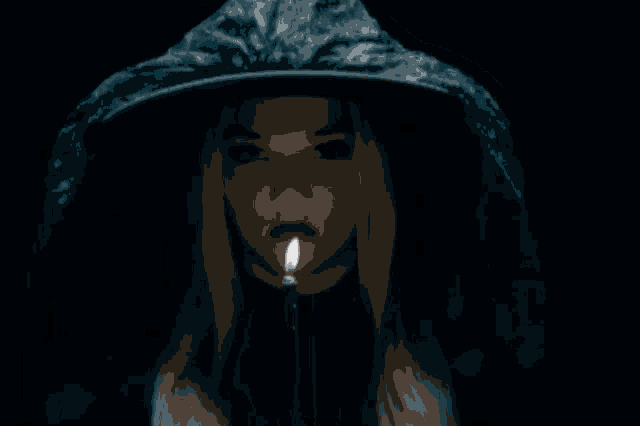 a woman wearing a hooded jacket is smoking a cigarette .