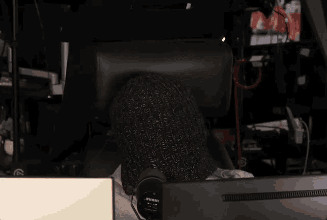 a person sitting in front of a computer with a microphone that says ' shure ' on it