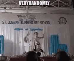 a group of people are standing on a stage in front of a banner that says st. joseph elementary school