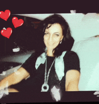 a woman in a black shirt is surrounded by hearts