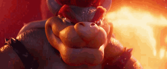 a close up of bowser 's face with fire in the background .