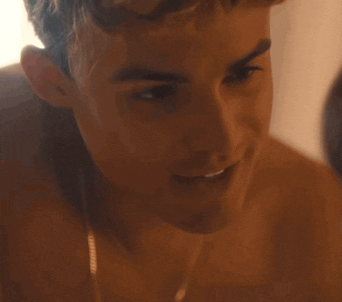 a close up of a shirtless man 's face smiling