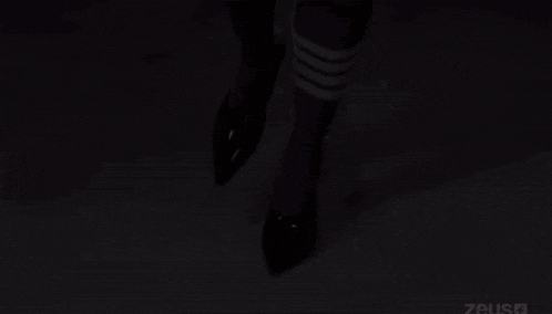 a woman wearing knee high socks and heels is walking