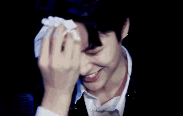 a man wipes his face with a napkin and smiles .