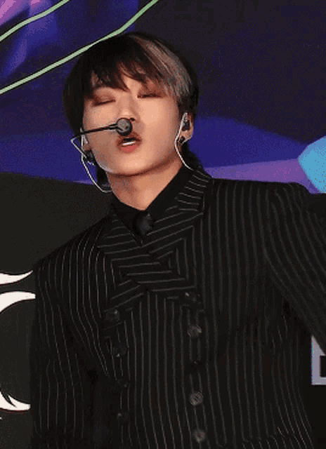 a close up of a person wearing a black striped jacket