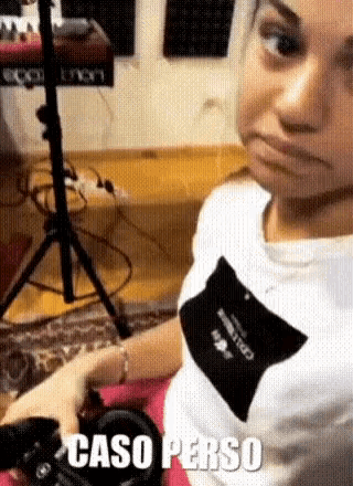 a woman is making a funny face while sitting on the floor in a room .