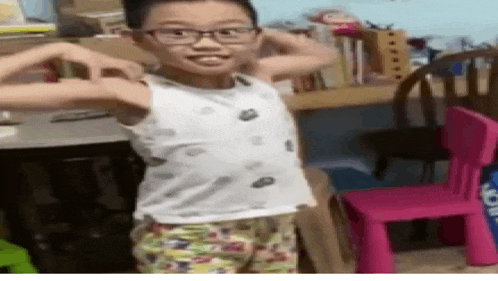 a young boy is flexing his muscles in a room .