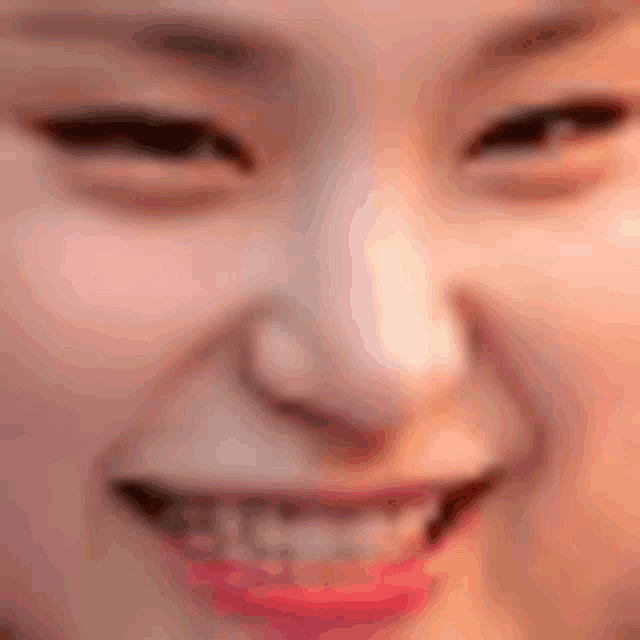a close up of a woman 's face with a smile and red lips .