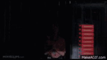 a woman in a pink shirt is standing in front of a wall with red lights on it .