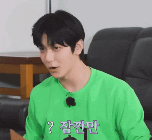 a man wearing a green shirt has a question mark on his shirt