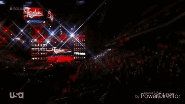 a female wrestler is dancing on a stage in front of a crowd with usa written on the bottom