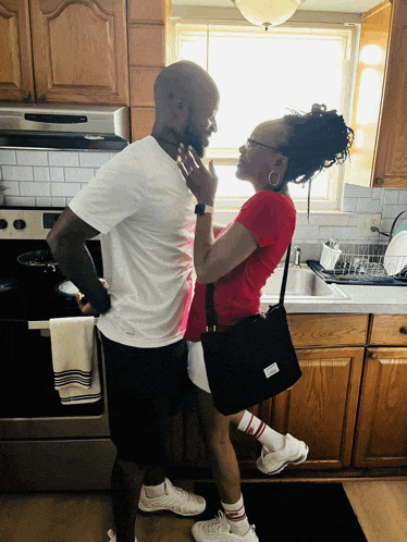 a man and a woman are standing in a kitchen