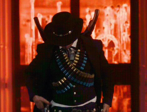 a man in a cowboy hat is holding a gun in his hand