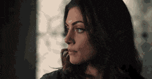 a close up of a woman 's face with a window in the background .