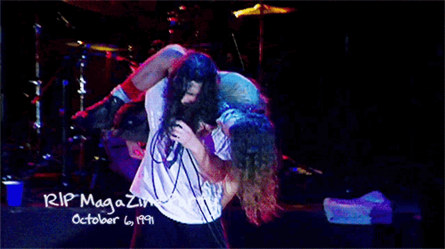 a man in a white shirt is carrying another man on his shoulders