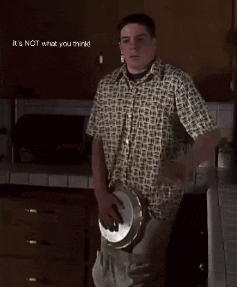 a man in a plaid shirt is standing in a kitchen with his pants down and a pot in his hand ..