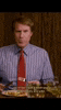 a man in a striped shirt and red tie is sitting at a table eating .
