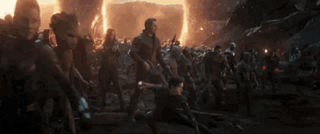 a group of people are standing next to each other in front of a fireball .