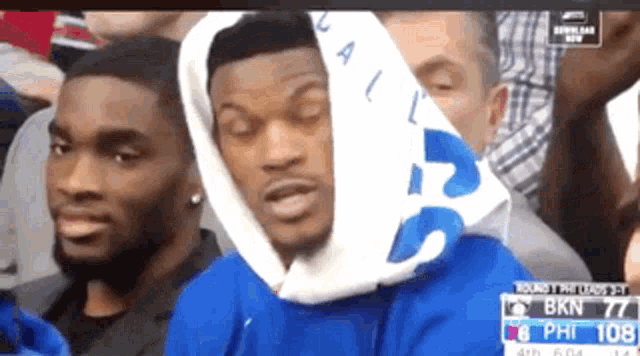 a man wearing a blue sweatshirt with the number 108 on the bottom