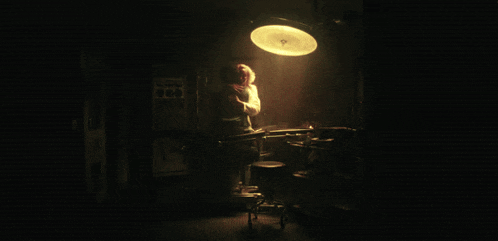 a woman in a white shirt is hugging another woman in a dark room