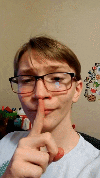 a young man wearing glasses is making a shhh gesture