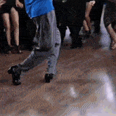 a man in a blue shirt is dancing on a dance floor .