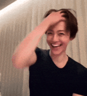 a man in a black shirt is smiling while scratching his head .