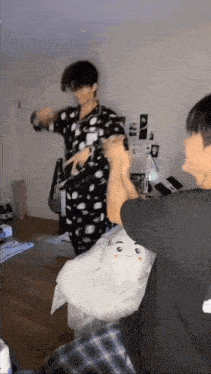 a group of young men are standing in a room playing with a stuffed animal .