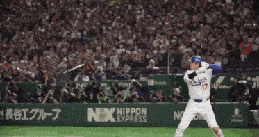 a baseball player wearing a number 17 jersey stands in front of a crowd