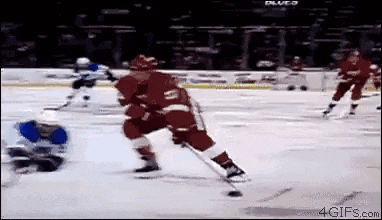 a group of hockey players are playing hockey on a rink .