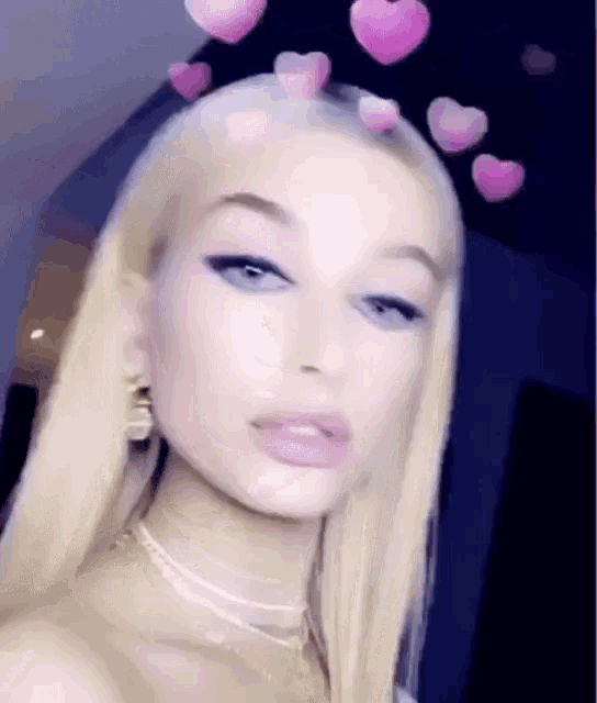 a close up of a woman 's face with pink hearts in her hair