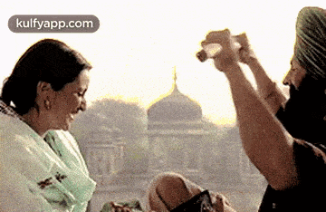 a man is taking a picture of a woman while sitting next to her .