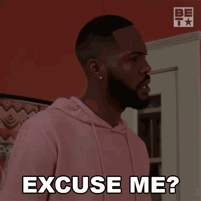 a man in a pink hoodie is saying " excuse me "