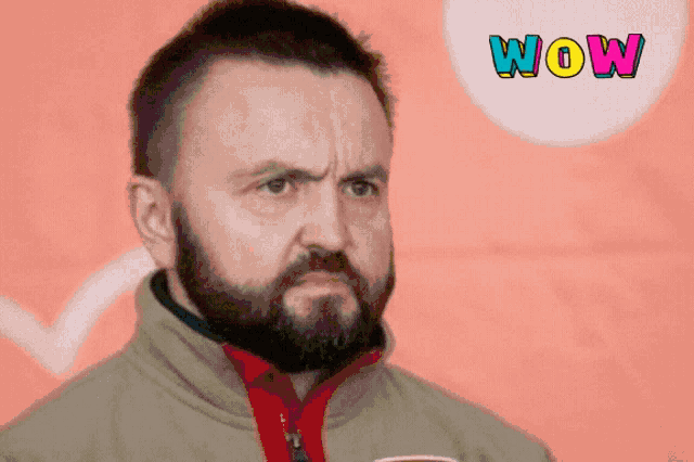 a man with a beard has a surprised look on his face and the word wow is on the bottom right
