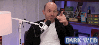 a man is giving a thumbs up in front of a microphone with the words dark web behind him .