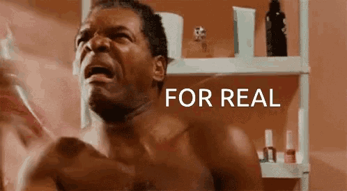 a shirtless man is crying in front of a bathroom shelf with the words for real on it