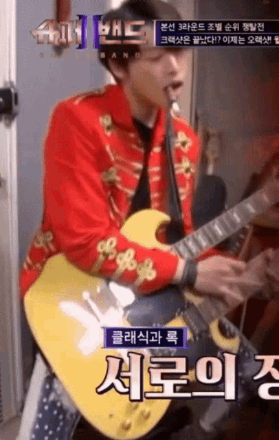 a man in a red jacket is playing a guitar with korean writing on it
