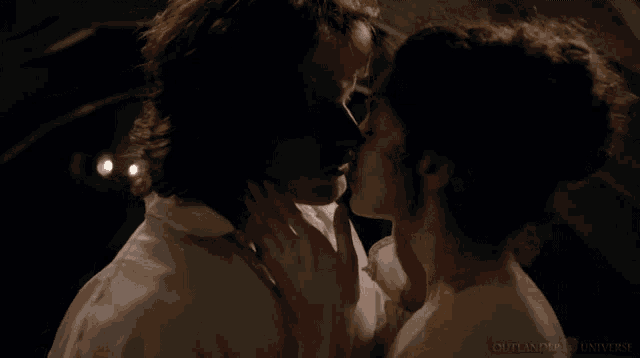 a man and a woman are kissing with the word outlander on the bottom