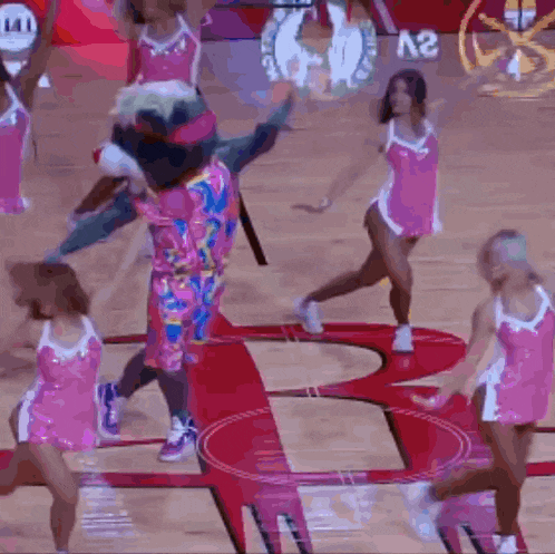 a group of cheerleaders are performing on a basketball court with the letter a2 in the background